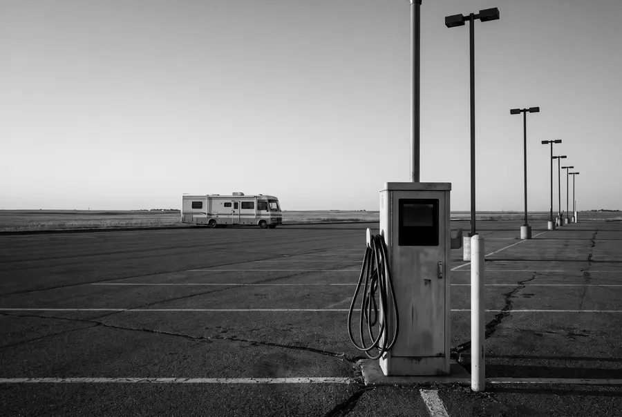 Charging pedestal and a distant motorhome on a big lot